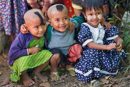 Myanmar,Burma,Rakhine State,Gyi Dawma. Three young friends at Gyi Dawma village. The small tufts of hair on the shaven heads of two of them are believed to protect them. Fotografie stock - Rights-Managed, Codice: 862-03365322