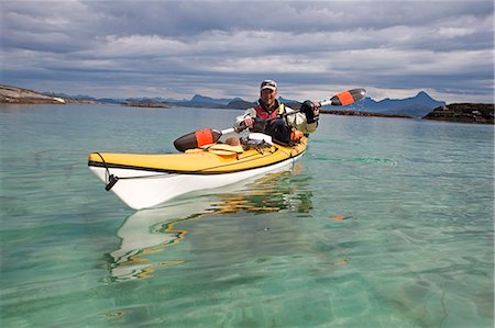 sports and kayaking - Norway,Nordland,Helgeland. Sea kayaking in coastal Norway during the summer,a guide demonstrated varoius kayaking strokes and techniques in a brightly coloured canoe. Stock Photo - Rights-Managed, Code: 862-03365681