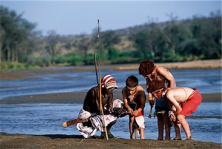 samburu - A Samburu moran teaches children the skills of being a warrior during a Cheli & Peacock family mobile safari. Foto de stock - Con derechos protegidos, Código: 862-03365963