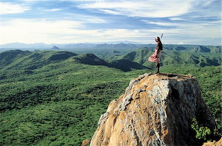 On a clear morning,a Samburu warrior looks out over miles of unspoilt semi-arid country to Mount Kenya,70 miles distant as the crow flies. Foto de stock - Con derechos protegidos, Código: 862-03366017