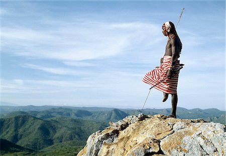 A Samburu warrior stands sentinel over a vast tract of unspoilt,semi-arid bush scrub country. The poor pasture here is an important resource for the pastoral Samburu people. Stock Photo - Rights-Managed, Code: 862-03366018