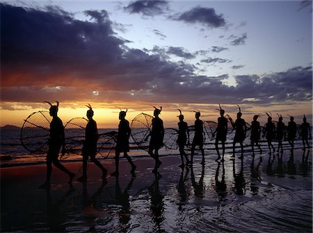 As the sun rises over Lake Turkana,a group of fishermen set out with their traditional fishing baskets to catch talapia in the lake's shallow waters. These traditional methods of fishing are now rare because the introduction of small mesh gillnets has resulted in a marked decline of fish stocks close to the shore. Foto de stock - Con derechos protegidos, Código: 862-03366076