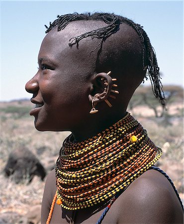 simsearch:862-03366129,k - A young Turkana girl has had the rims of her ears pierced in seven places and keeps the holes open with small wooden sticks. After marriage,she will hang leaf-shaped metal pendants from each hole. Stock Photo - Rights-Managed, Code: 862-03366112