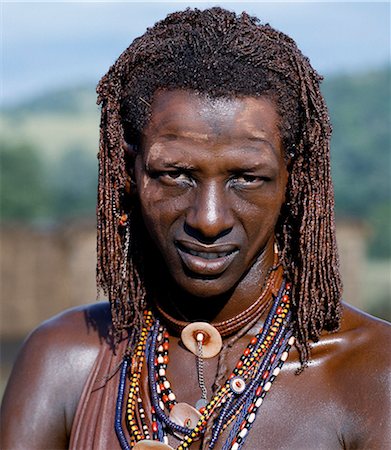 Un guerrier Masaï resplendissant avec ocrées de longues tresses. Son corps a été enduit d'ocre rouge, mélangé avec de la graisse animale tandis que les parties du visage ont été recouvertes de poudre ocre. Photographie de stock - Rights-Managed, Code: 862-03366150