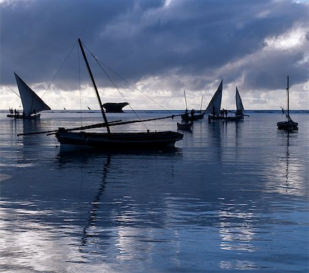 fishing dawn tranquil - Fishermen set out at daybreak in their traditional wooden craft,called in Ki-Swahili mashua,to fish beyond the coral reef,which lies less than half a mile offshore. The reef gives them protection from the high seas of the Indian Ocean during the monsoon winds. Stock Photo - Rights-Managed, Code: 862-03366412