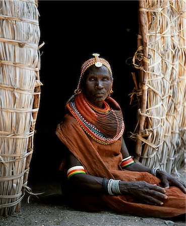 simsearch:862-03366188,k - Une femme de Turkana, assis devant la porte de sa hutte. Son collier lourd mporro tressé elle identifie comme une femme mariée. Typique de sa tribu, elle porte beaucoup de couches de colliers de perles et un bandeau perlé. Photographie de stock - Rights-Managed, Code: 862-03366496