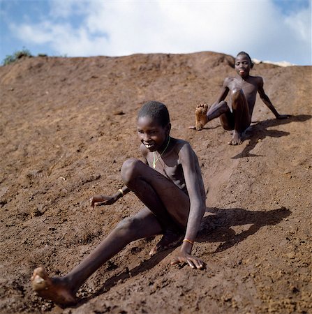 slide - Young Samburu boys enjoy themselves on a mudslide. Foto de stock - Con derechos protegidos, Código: 862-03366586