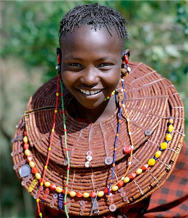 simsearch:862-03364165,k - A young Pokot girl wears large necklaces made from the stems of sedge grass,which are then plastered with a mixture of animal fat and red ochre before being decorated with buttons and beads. Fotografie stock - Rights-Managed, Codice: 862-03366603