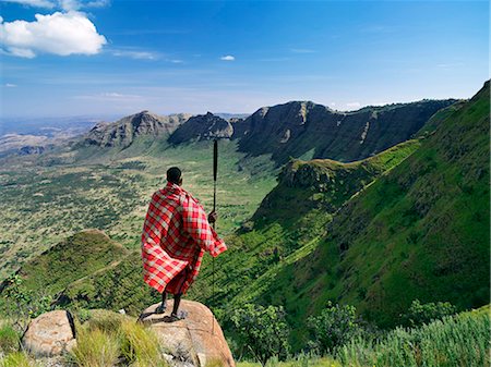 samburu - A Samburu warrior gazes at the eastern scarp of Africa's Great Rift Valley at Losiolo,north of Maralal. From 8,000 feet the land tumbles away 3,000 feet into rugged country,the domain of nomadic pastoralists,before rising again 75 miles away. The views at Losiolo are the most spectacular in Kenya of the largest,longest and most conspicuous physical feature of its kind on earth. Foto de stock - Con derechos protegidos, Código: 862-03366616
