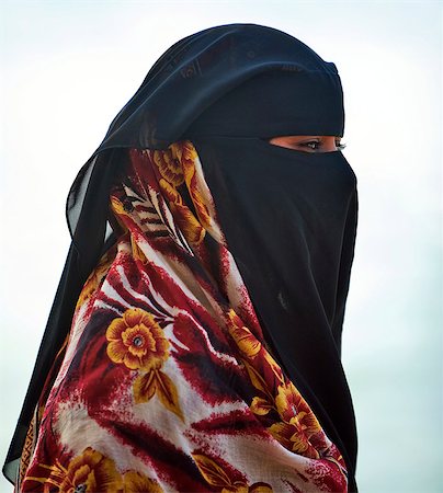 Kenya,Lamu Island,Shela. A Muslim woman with a face veil wearing a brightly coloured wrap. Stock Photo - Rights-Managed, Code: 862-03366741