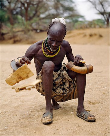 Kenya,Rift Valley Province,Kapedo. A Turkana soothsayer foretells the future and unravels the past by 'throwing’ a pair of traditional leather sandals and interpreting events by the pattern they form on the ground. These sandals must never be worn. Stock Photo - Rights-Managed, Code: 862-03366770