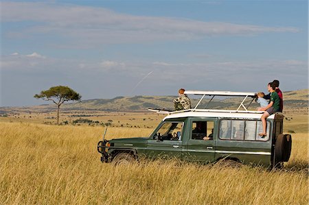 Kenya,Masai Mara National Reserve. Family on a game drive in a Toyota Landcruiser in the open grassy plains of the Masai Mara. Foto de stock - Direito Controlado, Número: 862-03366878