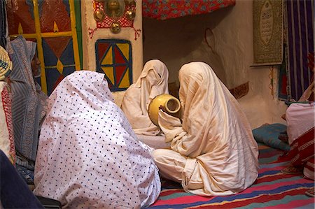 Veiled women drum and sing during the three day festival in Ghadames,an ancient trading town at the gateway to the Sahara,Libya. Stock Photo - Rights-Managed, Code: 862-03367153