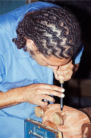 New Zealand,North Island,Rotorua. The New Zealand Maori Art and Crafts Institute in Te Puia Maori Village - a local Maori man demonstrates wood carving decorations. Stock Photo - Rights-Managed, Code: 862-03360085