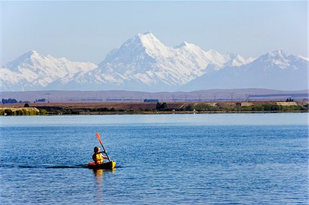 simsearch:862-03289075,k - New Zealand,South Island,Mackenzie Country. Kayaking on Lake Benmore and a distant Aoraki Mount Cook (3754m),New Zealand and Australasia's highest mountain. Lake Benmore is a non-touristy camping area popular with domestic holidaymakers. Stock Photo - Rights-Managed, Code: 862-03360112