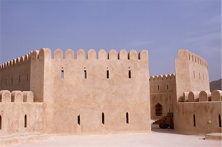 simsearch:862-03437387,k - A watchtower within Al Hazm Castle. The magnificent 18th century military stronghold makes full use of traditonal Omani defensive features boasting a massive wooden entry door,secret escape tunnels,dungeons,cannon towers,gun ports and a machicolation for pouring boiling date syrup on attackers. Fotografie stock - Rights-Managed, Codice: 862-03360176