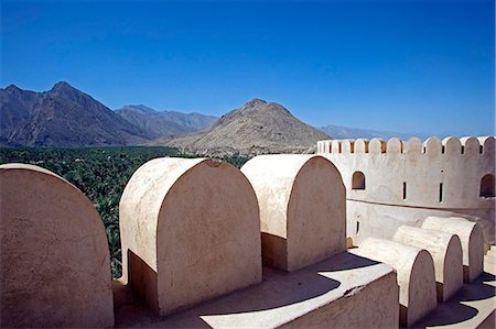 simsearch:862-03437387,k - Oman,Batinah Plain,Rustaq. Rustaq fort,built four centuries prior to the dawn of Islam in Oman,is an imposing structure built on three levels,containing separate houses,an armoury,a mosque and four towers. The tallest tower stands over 18.5m high and has a diameter of 6m. Fotografie stock - Rights-Managed, Codice: 862-03360290
