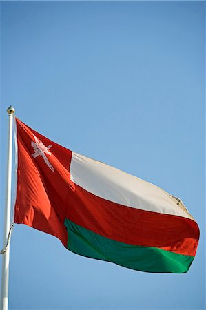 Oman. Le drapeau National - cet indicateur contient blason du pays qui est un poignard khanjar dans une gaine qui est superposée à deux épées croisées. C'est le symbole traditionnel de l'Oman. On le trouve sur nombreux drapeaux ainsi que la monnaie d'Oman. Photographie de stock - Rights-Managed, Code: 862-03360324