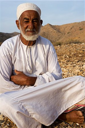 Oman, Mascate région, Bandar Khayran. Un vieux fermier s'assied pour un chat habillé en costume omanais traditionnel. Photographie de stock - Rights-Managed, Code: 862-03360335