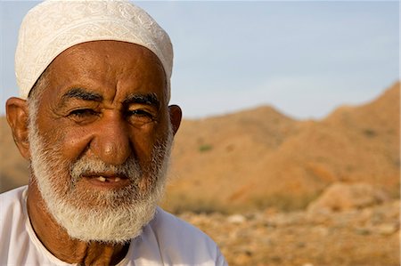 Oman, Mascate région, Bandar Khayran. Un vieux fermier s'assied pour un chat habillé en costume omanais traditionnel. Photographie de stock - Rights-Managed, Code: 862-03360336