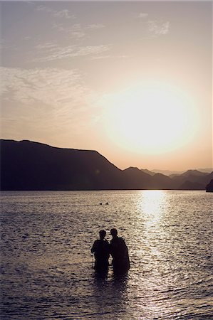 simsearch:862-03437387,k - Oman,Muscat Region,Bandar Khayran. As the sun sets two divers exit the water after and evening dive on one of Omans many tropical reefs. Stock Photo - Rights-Managed, Code: 862-03360337