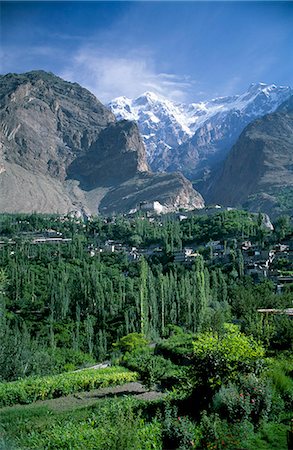 simsearch:862-03360380,k - In the foreground are the lush orchards of the old town of Baltit and beyond to the north are the Karakorums with the peak of Ultar II visible Foto de stock - Direito Controlado, Número: 862-03360385