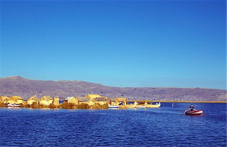 puno - Un homme indien lignes son bateau une antenne de l'Uros ou îles rouges flottants sur le lac Titicaca Photographie de stock - Rights-Managed, Code: 862-03360447