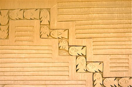 Adobe wall frieze incorporating a fish and wave design in the Audience Rooms of the Tschudi Complex - one of the Royal Compounds at the Chimu site of Chan Chan,near Trujillo in northern Peru. Fotografie stock - Rights-Managed, Codice: 862-03360479