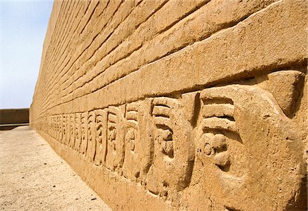 The adobe walls of the Ceremonial Courtyard in the Tschudi Complex,decorated with bas relief designs featuring sea otters and waves. The Complex is part of the ancient Chimu site of Chan Chan,in northern Peru Fotografie stock - Rights-Managed, Codice: 862-03360489