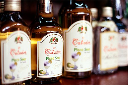 Bottles of Pisco Sour are lined up for tasting,at a bodega (vineyard) on the outskirts of Ica,in southern Peru. Pisco Sour,a white-grape brandy,is the Peruvian national drink. Stock Photo - Rights-Managed, Code: 862-03360527