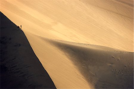 sand dunes large - Hikers are dwarfed by a giant sand dune above the desert oasis of Huacachina,near Ica in southern Peru Stock Photo - Rights-Managed, Code: 862-03360523