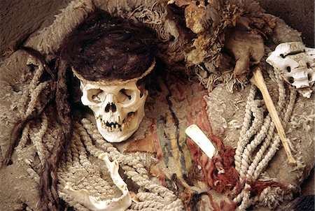 simsearch:862-03360456,k - Le crâne d'une momie de Nazca, entouré par des fragments de poterie, des os et des tissus dans le cimetière de Chauchilla, sud du Pérou. Photographie de stock - Rights-Managed, Code: 862-03360552