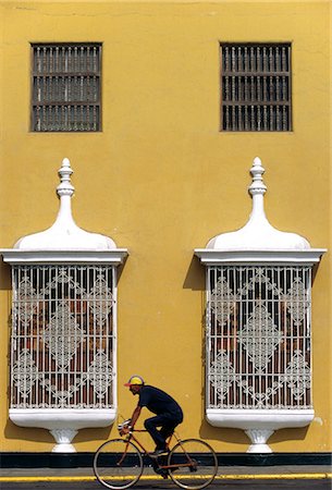 simsearch:862-03360743,k - A cyclist passes the pastel shades and colonial architecture of a mansion on the Plaza de Armas,in Trujillo,Peru Foto de stock - Con derechos protegidos, Código: 862-03360578