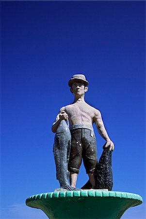 A statue of a pescador (fisherman) pays tribute to the early origins of the resort village of Mancora,on the north coast of Peru Fotografie stock - Rights-Managed, Codice: 862-03360600