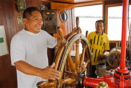 peruvian man - Peru,Amazon,Amazon River. Crew steering the Ayapua Riverboat up the Amazon River. . Stock Photo - Rights-Managed, Code: 862-03360645