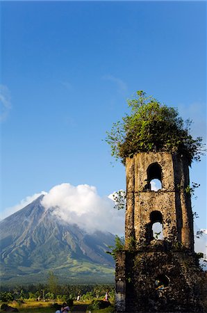 Philippines,Luzon Island,Bicol Province. Cagsawa Church Belfrey Ruins and Mount Mayon (2462m). Near Perfect Volcano Cone with plume of smoke. This location is where 1200 people were buried alive in the 1814 eruption. Foto de stock - Con derechos protegidos, Código: 862-03360779