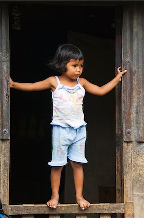 filipino - Philippines,Luzon Island,The Cordillera Mountains,Kalinga Province near Tinglayan. Buscalan Village - girl standing in window frame. Foto de stock - Con derechos protegidos, Código: 862-03360810