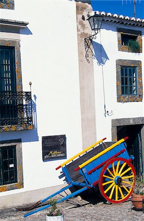 A brightly painted cart sits outside an arts & craft shop in the hilltop village of Alantejo. Stock Photo - Rights-Managed, Code: 862-03360842