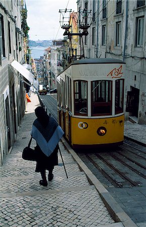 funiculaire - Une vieille femme descend pas passé le funiculaire Elevador da Bica qui relie l'Alto de Bairo est proche du PCSRA faire station Sodre Photographie de stock - Rights-Managed, Code: 862-03360861