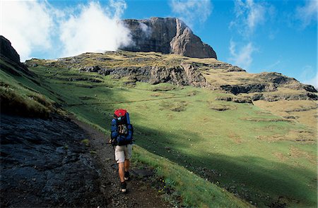 A walker follows a trail leading up into the Drakensberg Mountains towards Mont-aux-Sources Stock Photo - Rights-Managed, Code: 862-03361191