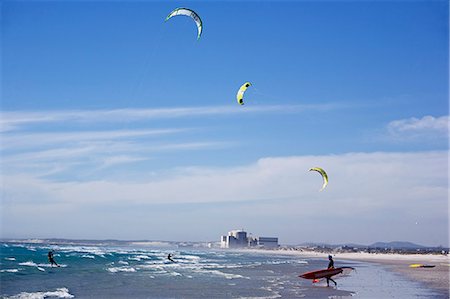 South Africa,Western Cape,Cape Town. Kite surfers at Melkbosstrand,with the nuclear power station at Koeberg behind them,enjoy a fine blustery Sunday afternoon on the beach. Stock Photo - Rights-Managed, Code: 862-03361258