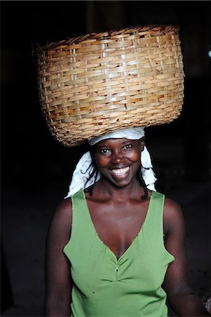 santomean - A Sao Tomense woman carries a basket full of cocoa beans at the cocoa processing plant in Agua Izé,a small Sao Tomense village. Cocoa is the country's chief export. Sao Tomé and Principé is Africa's second smallest country with a population of 193 000. It consists of two mountainous islands in the Gulf of New Guinea,straddling the equator,west of Gabon. Stock Photo - Rights-Managed, Code: 862-03361284