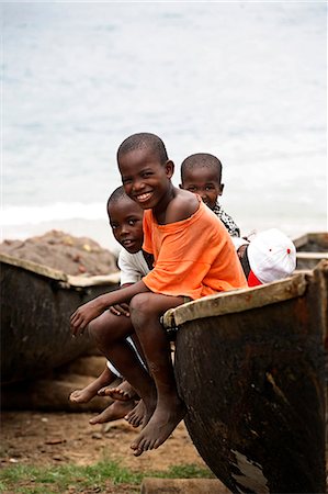 Children sit on a fishing boat made of bamboo in the village of Porto Alegre in the south of Sao Tomé and Principé. Sao Tomé and Principé is Africa's second smallest country with a population of 193 000. It consists of two mountainous islands in the Gulf of New Guinea,straddling the equator,west of Gabon. Stock Photo - Rights-Managed, Code: 862-03361303