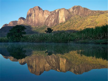 Massif de Tsaranora reflected in a river in the early morning. The spectacular granite peaks and domes of the Andringitra Mountains have become a popular hiking destination. Stock Photo - Rights-Managed, Code: 862-03363994
