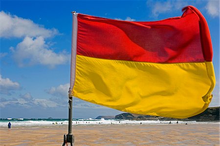 simsearch:862-03710952,k - Prominantly displayed lifeguards flag on Harlyn Bay Beach during the height of summer holidays Stock Photo - Rights-Managed, Code: 862-03437045