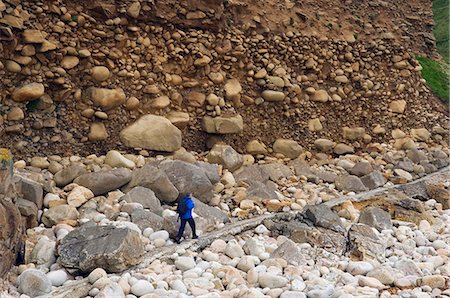 simsearch:862-03353358,k - A walker on the Cornish coastal path walks beneath a steep cliff showing signs of coastal erosion in the Cot Valley,Cornwall,England Foto de stock - Con derechos protegidos, Código: 862-03437049