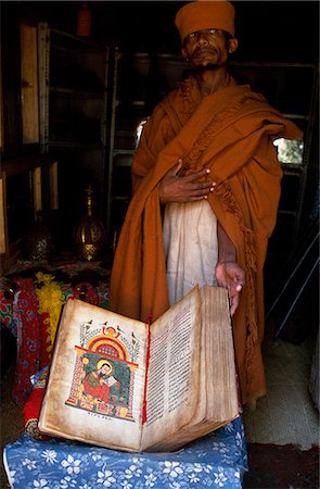 A priest at Kebran Gabriel Church shows one of its many ancient illustrated books; the church has the largest library in the Tana region. Foto de stock - Con derechos protegidos, Código: 862-03437078