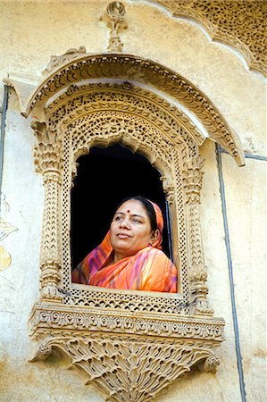 simsearch:862-03289805,k - Inde, Rajasthan, Jaiselmer, Patwon ki Haveli. Lady habillée traditionnellement habillée ressemble d'une des fenêtres lourdement décorés dans celui en mieux Havelis préservé de la ville. Photographie de stock - Rights-Managed, Code: 862-03437119