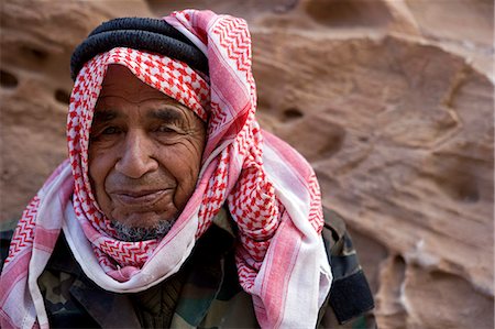 Jordan,Petra. Portrait of local beduin caretaker resting on the steps of the 'Hidden Way',the secret entrance to the rear of the ancient Nabataean tradiing capital of Petra. Stock Photo - Rights-Managed, Code: 862-03437150