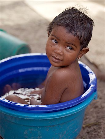 A young Malagasy girl takes a bath in a large plastic bowl in the fishing village of Ramena near Antsiranana (formerly Diego Suarez). Stock Photo - Rights-Managed, Code: 862-03437215